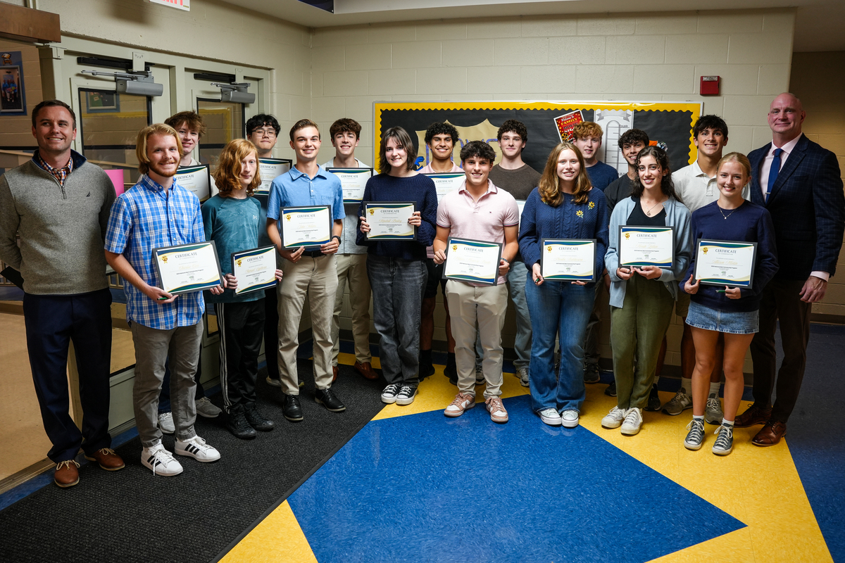 students pose for a photo holding certificates for the National Merit Scholarship program