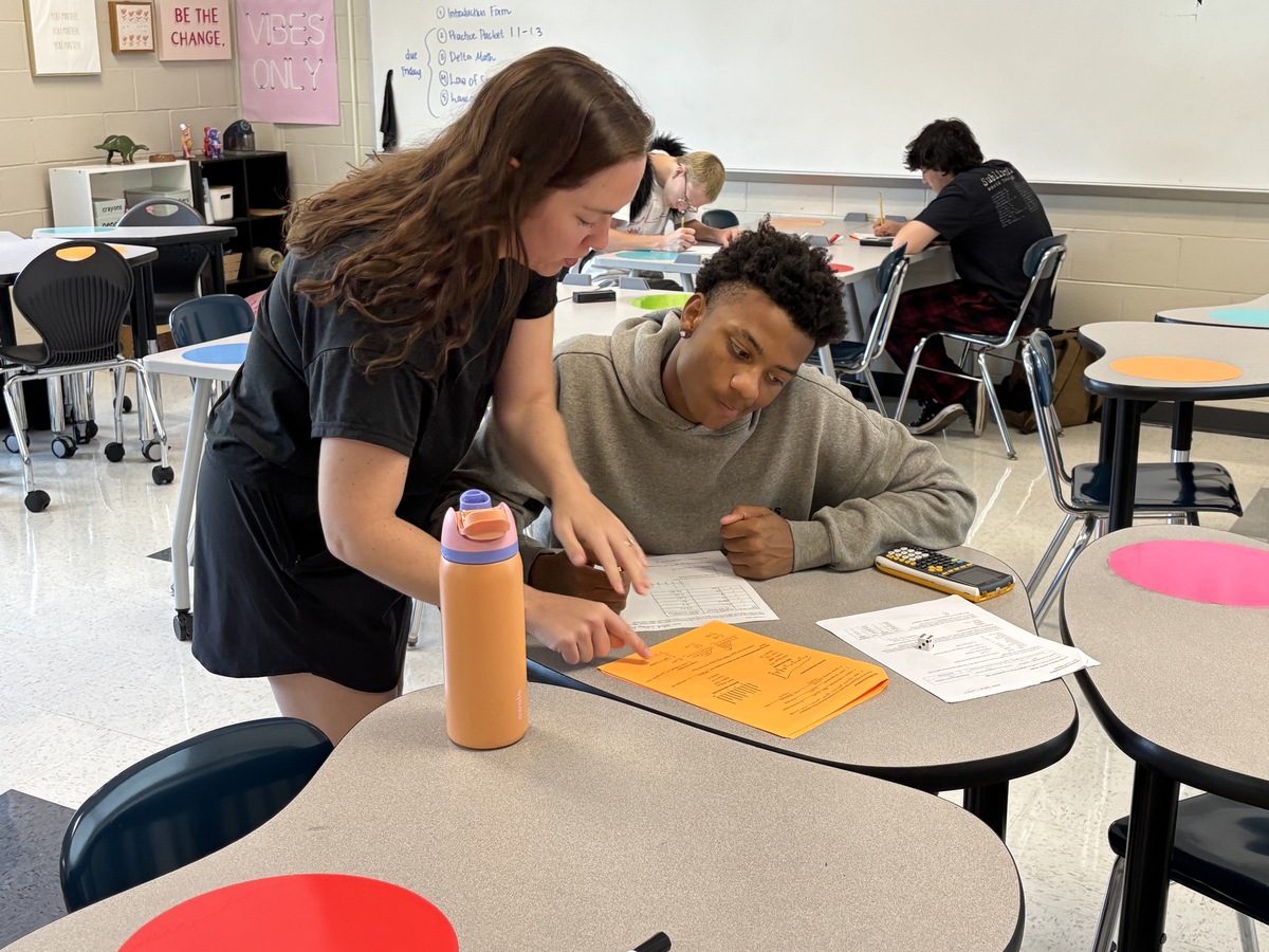 teacher helping student with worksheet