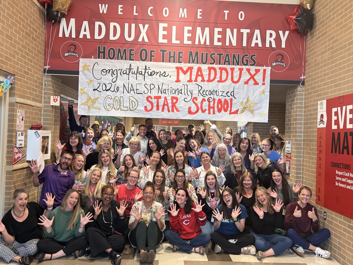 Maddux staff pose for a group photo with a banner that says "congratulations, Maddux! 2026 NAESP Nationally recognized Gold Star school."