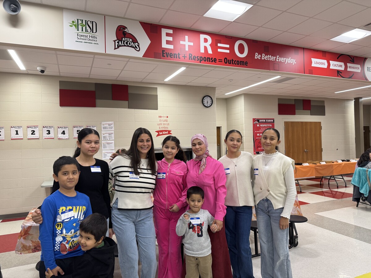 students and family members pose for a photo with a teacher