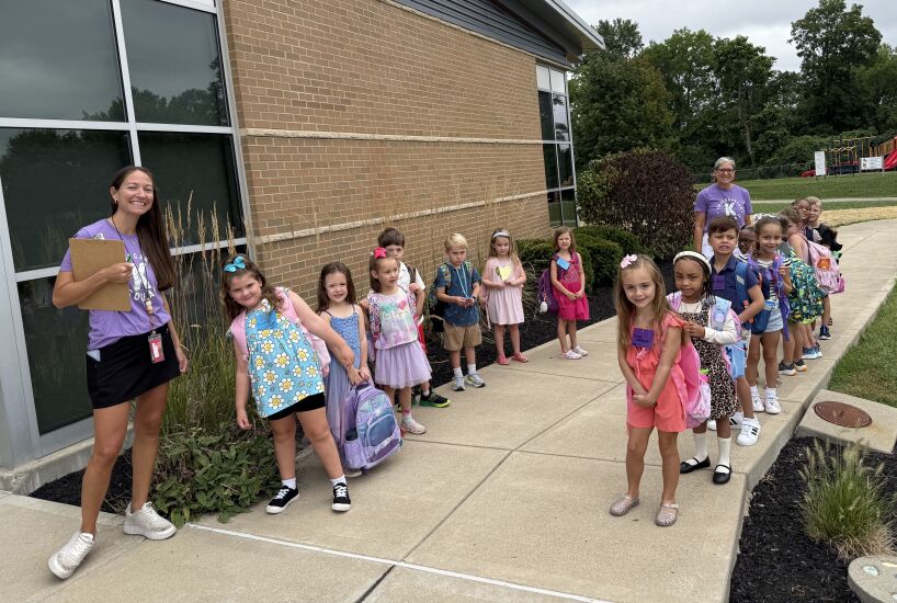 kindergarten students smile and line up for the first day of school