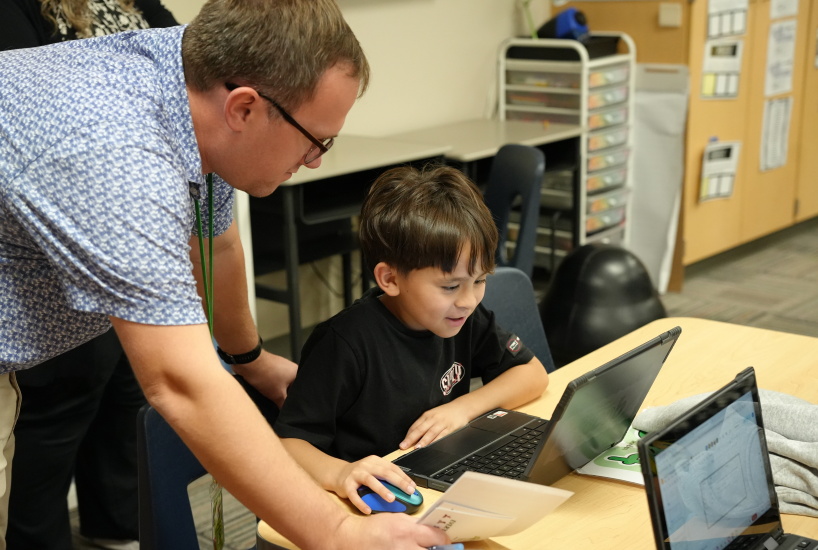 staff member helps a student on their computer