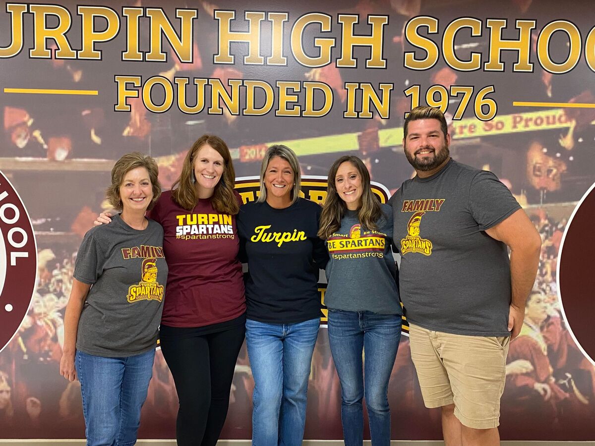 Turpin High School Staff in front of banner
